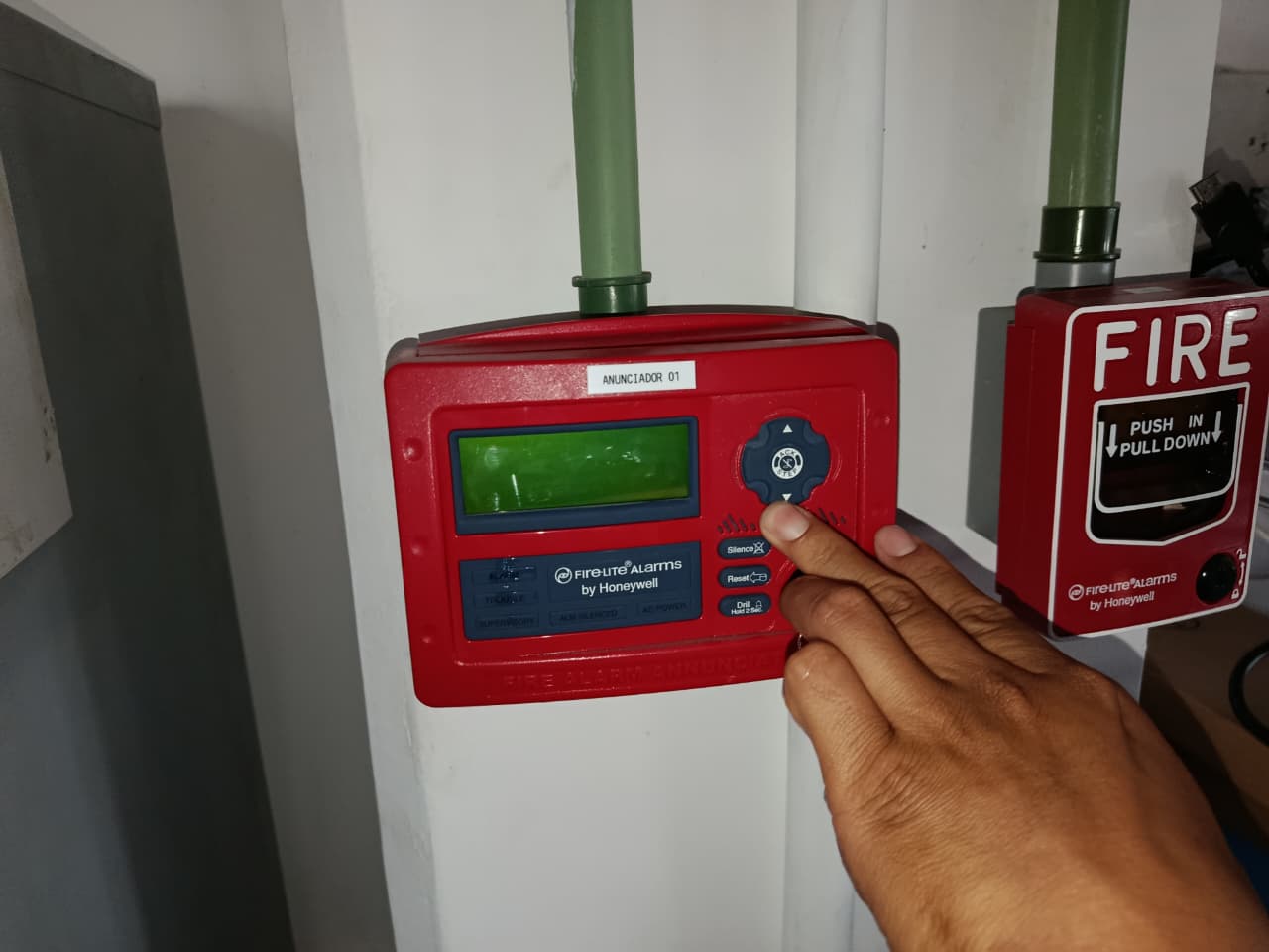 Técnico de Orión Integradores probando un panel anunciador y estación de jalado contra incendio