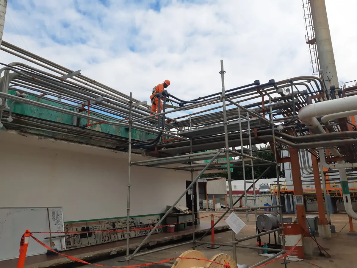 Técnico de Orión Integradores instalando fibra óptica en planta industrial